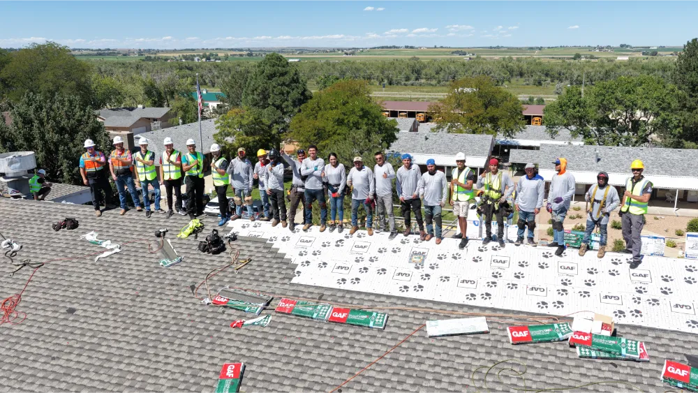 Semper Fi Roofing crew standing together on a roof with GAF underlayment installed during a replacement job.